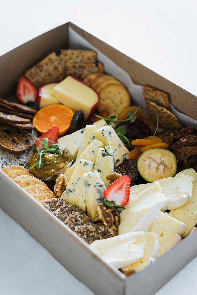 Boxed platter of artisan cheese, crackers and fruit