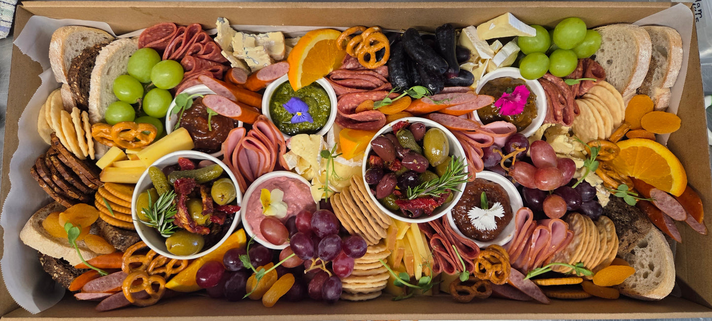 
                  
                    Arctic Kitchen's grazing platter filled with sliced meats, cheeses, crackers, grapes, olives, fruit, dips and spreads.
                  
                