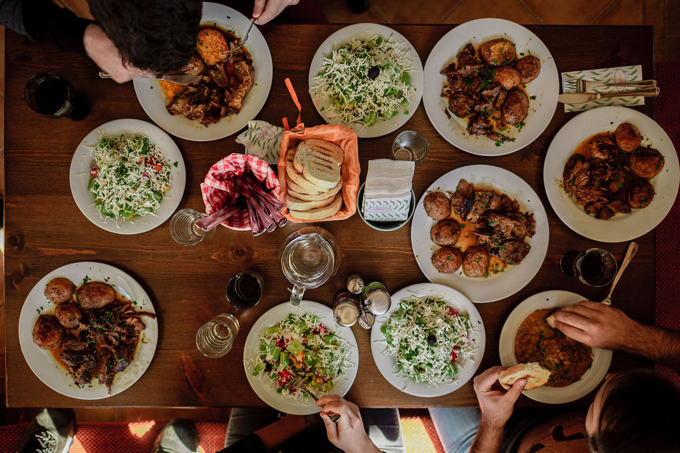 People eating dinner at a table, with a variety of different meals 