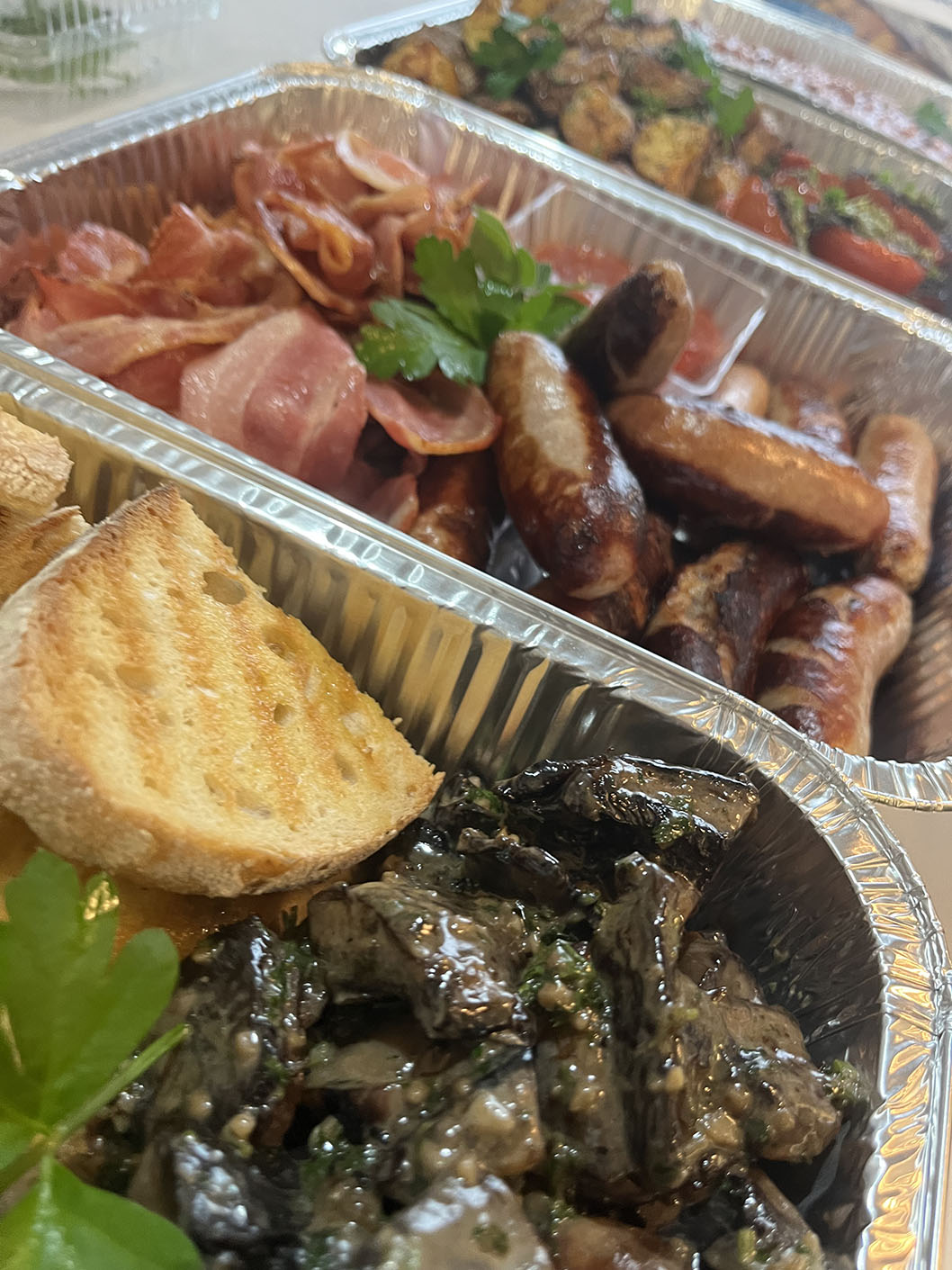 Cooked breakfast platter - sausages, bacon, potatoes, beans, tomatoes, mushrooms and toast