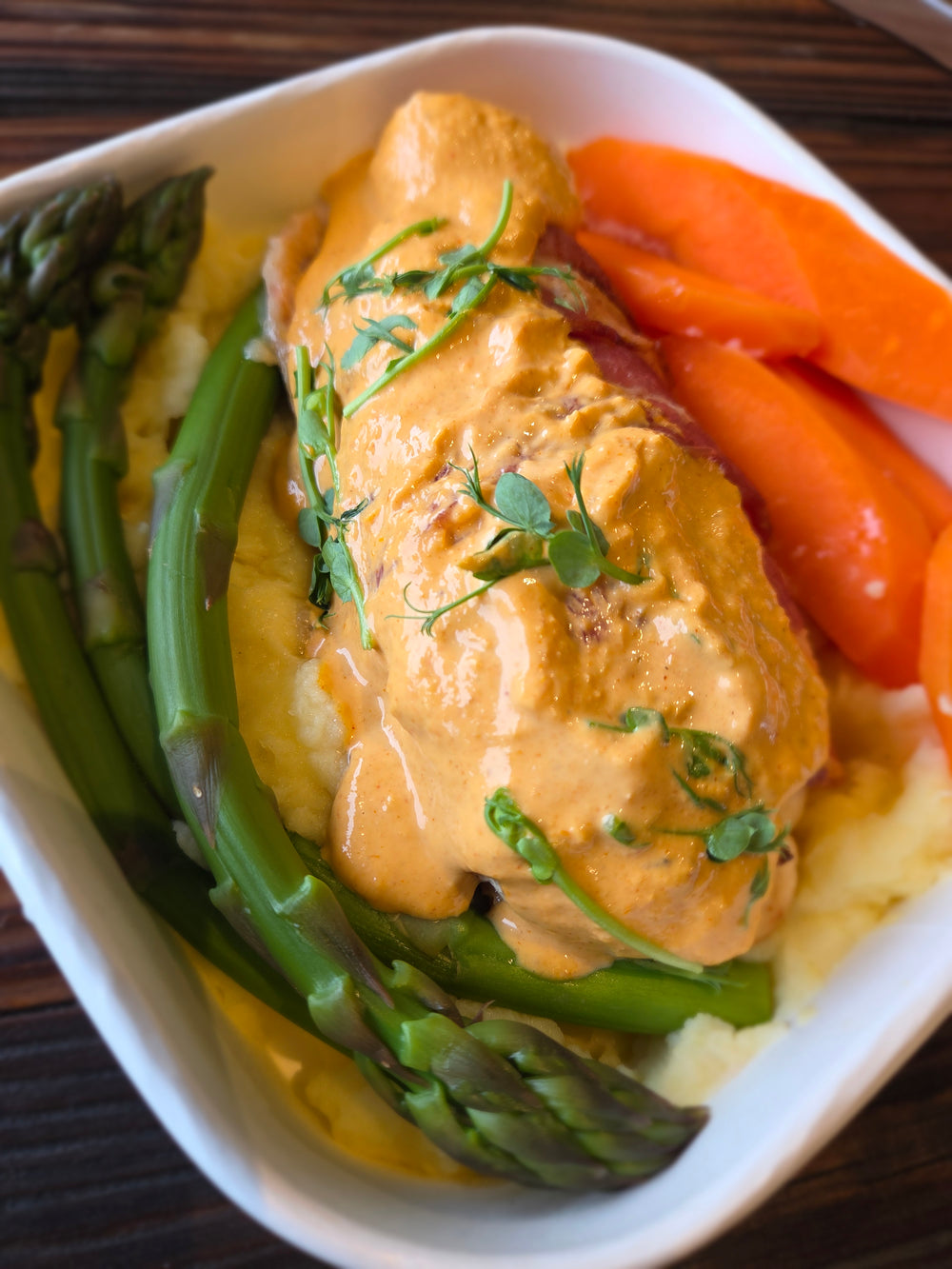 Roasted chicken breast wrapped in bacon with roast kumara, courgette, Brussels sprouts & herby cheese sauce